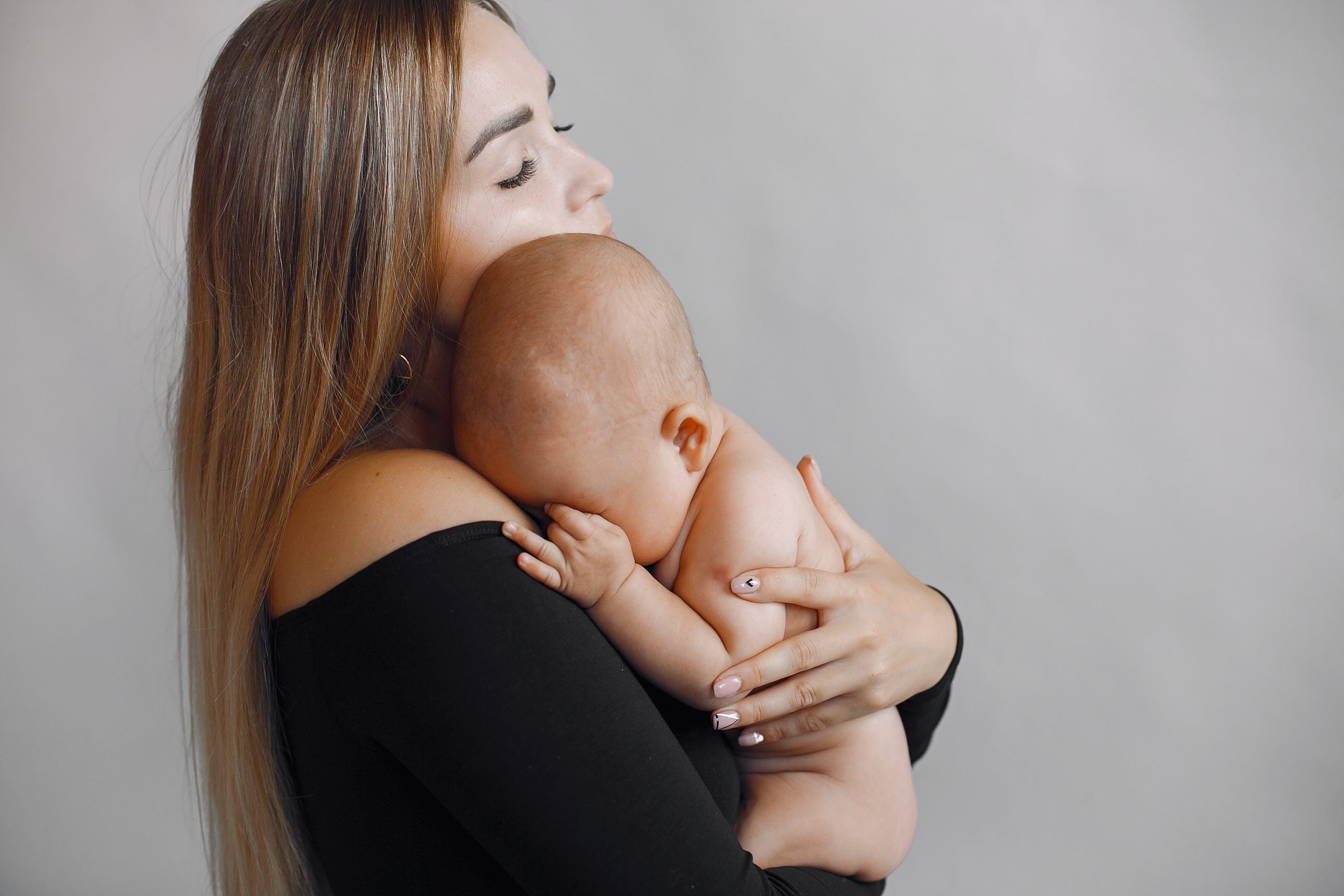 Elegant mother with cute little daughter in a studio